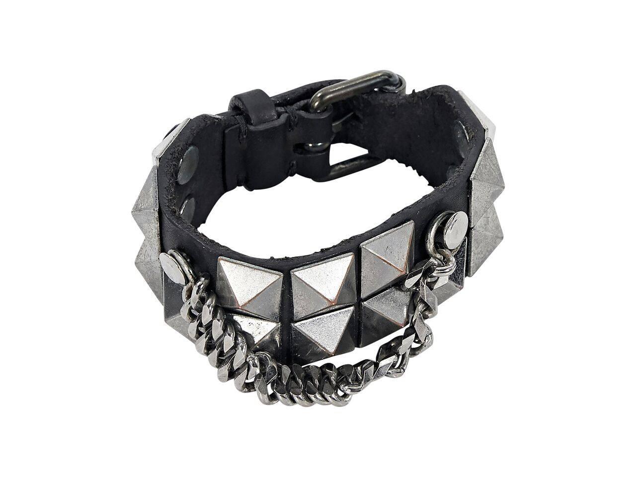 Product details:  Black leather cuff bracelet with pyramid studs by Burberry.  Adjustable buckle closure.  Hanging chain detail.  Gunmetal-tone hardware.  10.75