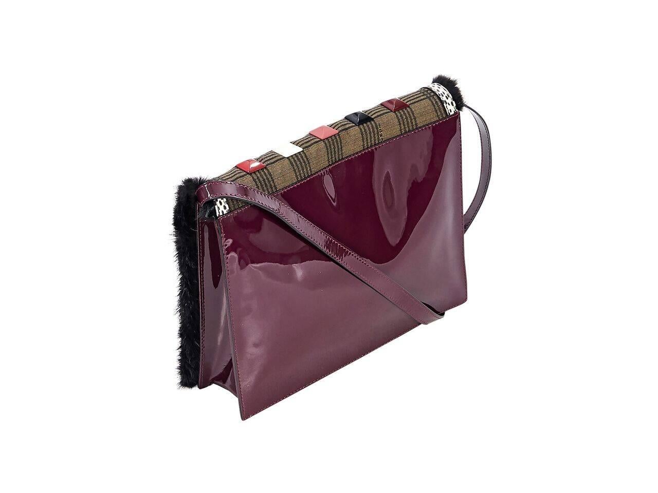 Product details:  Burgundy patent leather crossbody bag by Fendi.  Trimmed with black mink fur.  Adjustable, detachable crossbody strap.  Pyramid studded front flap.  Magnetic snap closure.  Lined interior with inner zip pocket.  Goldtone hardware. 