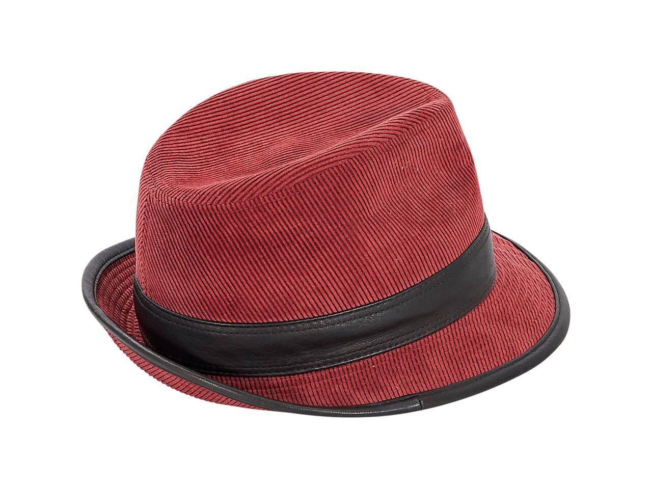 Product details:  Red corduroy trilby hat by Hermes.  Trimmed with black leather.  Inner sweatband.  Size 55. 
Condition: Pre-owned. Very good.
Est. Retail $ 978.00