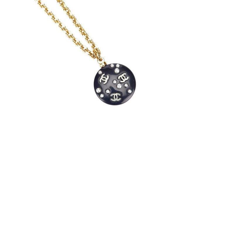 Product details:  Black round logo pendant necklace by Chanel.  Embellished plastic pendant.  Single goldtone chain design.  Hook closure.  1" drop.  Original box included.
Condition: Pre-owned. Good.
Est. Retail $ 945.00