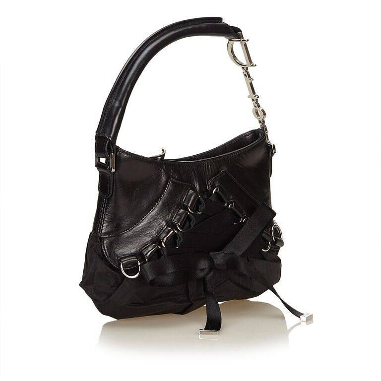 Product details:  Black leather and nylon Corset shoulder bag by Christian Dior.  Lace-up ribbon front.  Single shoulder strap.  Top zip closure.  Lined interior with inner zip pocket.  Silvertone hardware.  9"L x 7"H x 1"D.  6"