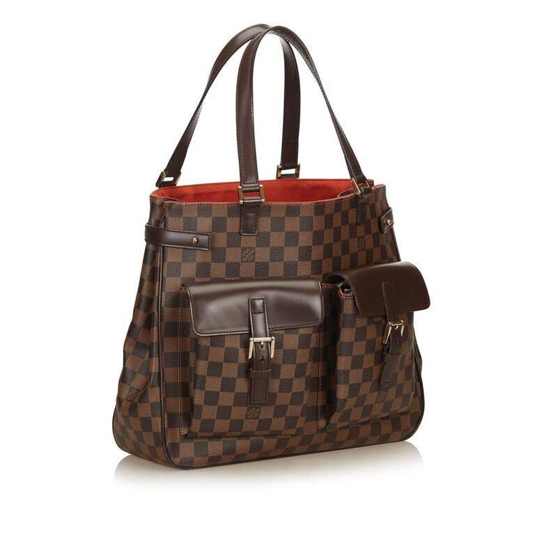 Product details:  Brown damier ebene canvas Uzes tote bag by Louis Vuitton.  Trimmed with leather.  Dual carry handles.  Open top.  Lined interior with inner zip pocket.  Front buckle flap pockets.  Goldtone hardware.  14"L x 12"H x