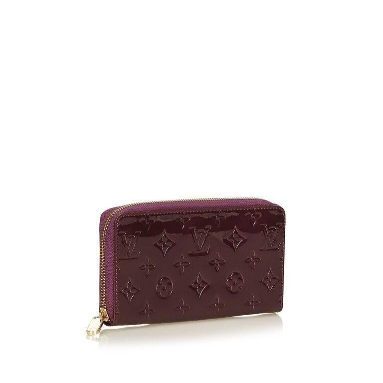 Product details:  Purple embossed vernis leather Zippy wallet by Louis Vuitton.  Zip-around closure.  Lined interior with inner credit card slots, bill compartments and zip coin pouch.  Goldtone hardware.  7"L x 4"H. 
Condition: Pre-owned.