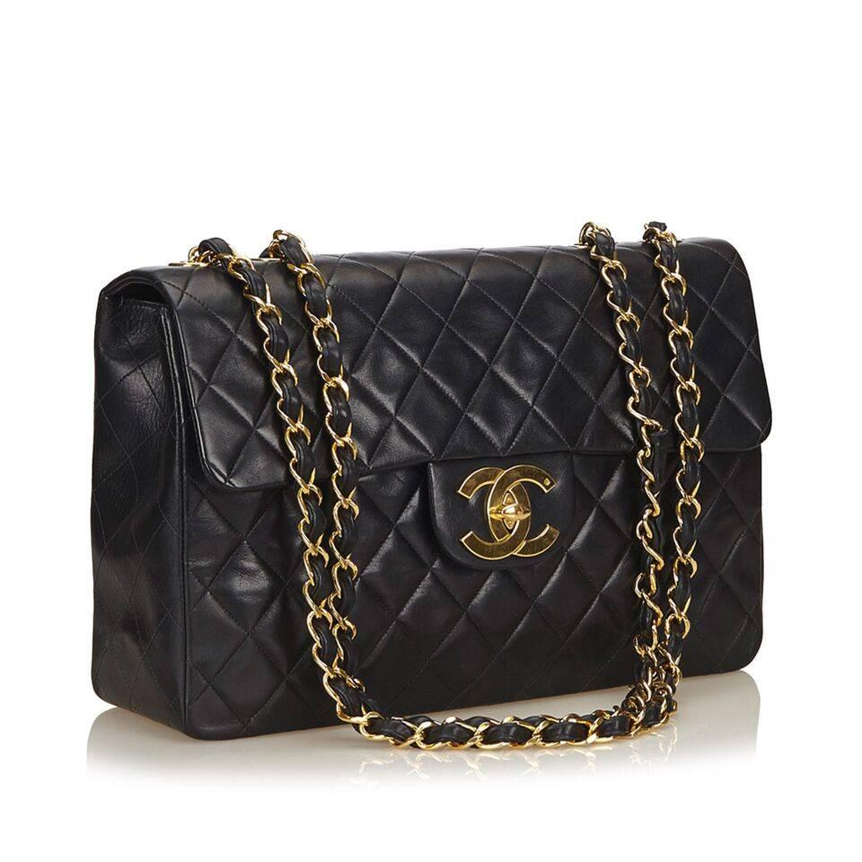 Product details:  Black quilted lambskin skin leather Maxi classic flap bag by Chanel.  Dual shoulder chain and leather straps.  Front flap.  Twist-lock logo closure.  Leather lined interior with inner zip and slide pockets.  Exterior back slide