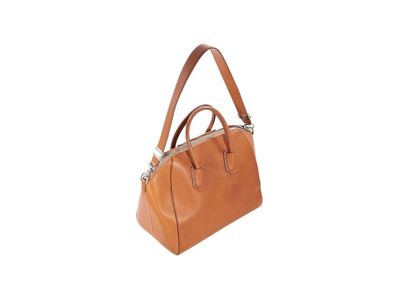 Product details:  Tan medium Antigona leather satchel by Givenchy.  Dual carry handles.  Detachable shoulder strap.  Top zip closure.  Lined interior with inner zip pocket.  Silvertone hardware. 
Condition: Pre-owned. Very good.
Est. Retail $