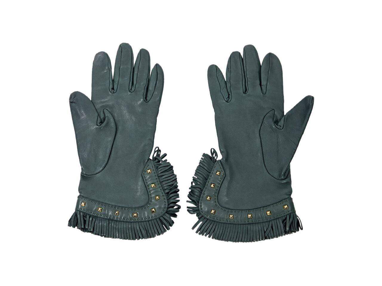Product details:  Green leather gloves by Hermes.  Side slit.  Fringed cuffs with studded trim.  Goldtone hardware.  Size 7.  
Condition: Pre-owned. Very good.
Est. Retail $ 970.00