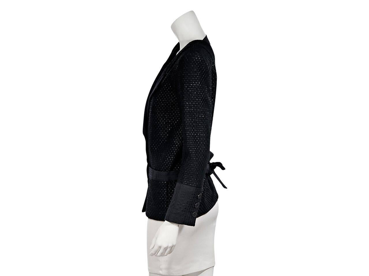 Product details:  Black lattice cotton-blend jacket by Chanel.  Notched lapel.  Long sleeves.  Three-button details at cuffs.  Double-breasted button-front closure.  Waist slide pockets.  Cutout back.  Back waist tie strap.  
Condition: Pre-owned.