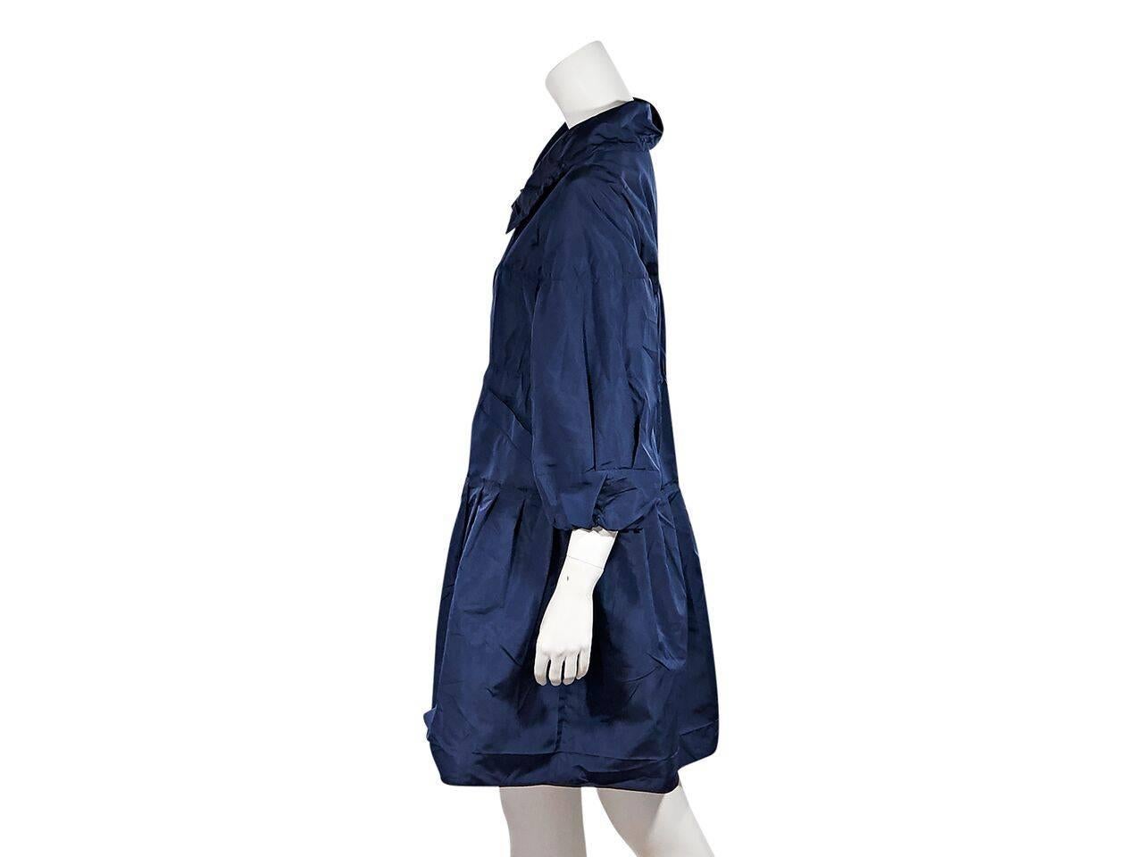 Product details:  Lightweight blue nylon coat by Prada.  Spread collar.  Three-quarter length sleeves.  Waist slide pockets.  Concealed front closure.  Pleated skirting. Label size IT 44.
Condition: Pre-owned. Very good.
Est. Retail $ 1,095.00