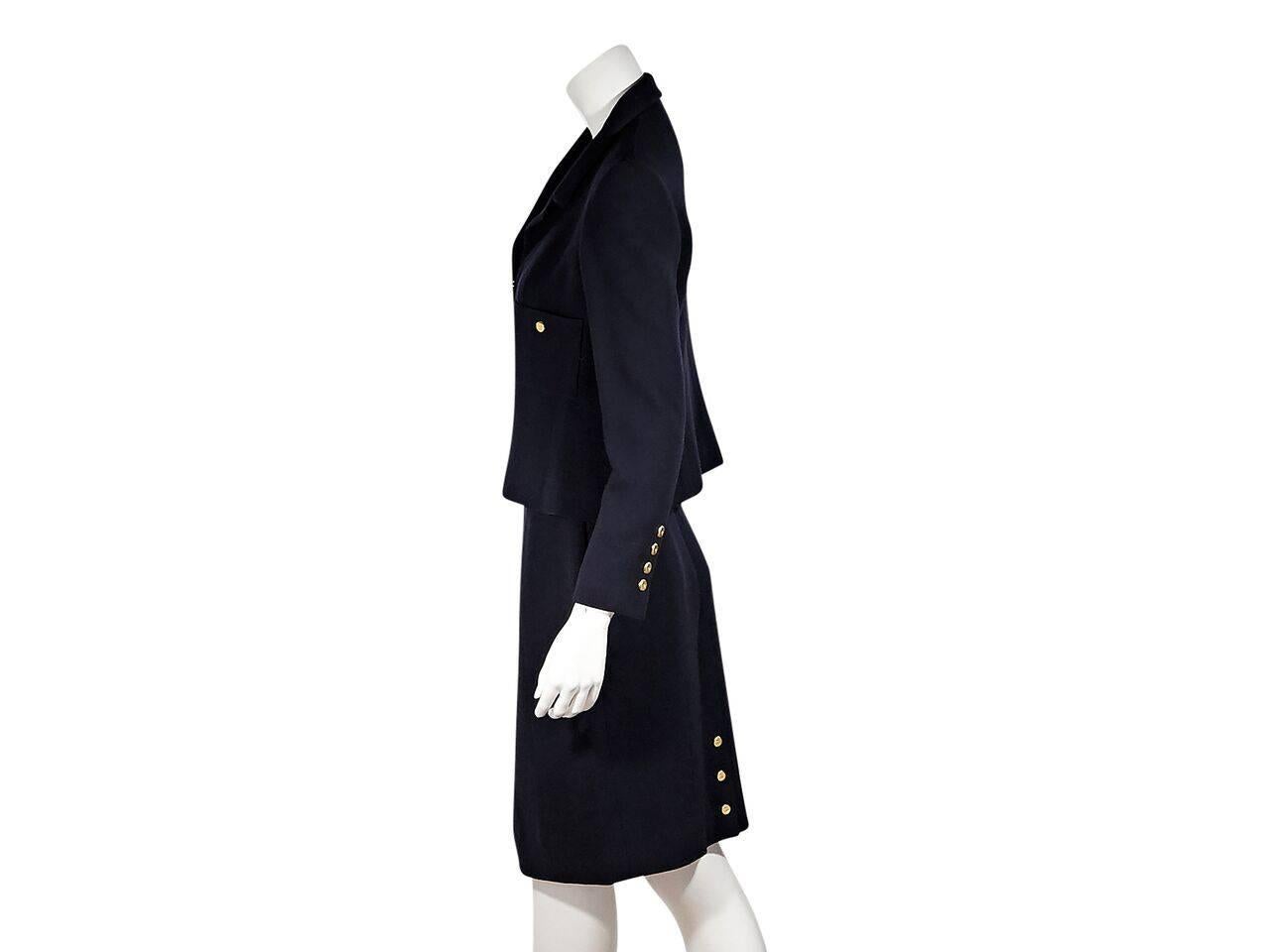 Product details:  Vintage navy blue skirt suit set by Chanel.  Notched lapel.  Bracelet-length sleeves.  Four-button detail at cuffs.  Concealed hook closure.  Chest patch pockets.  Matching pencil skirt.  Banded waist.  Concealed back zip closure. 