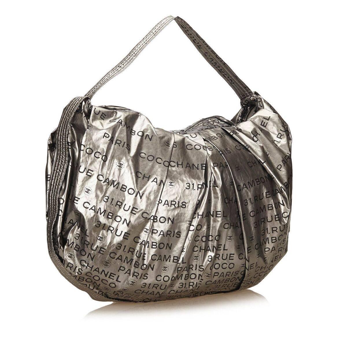 Product details:  Silver nylon Unlimited shoulder bag by Chanel.  Single shoulder strap.  Top zip closure.  Lined interior with inner zip and open pockets plus a key fob strap.  Silvertone hardware.  26