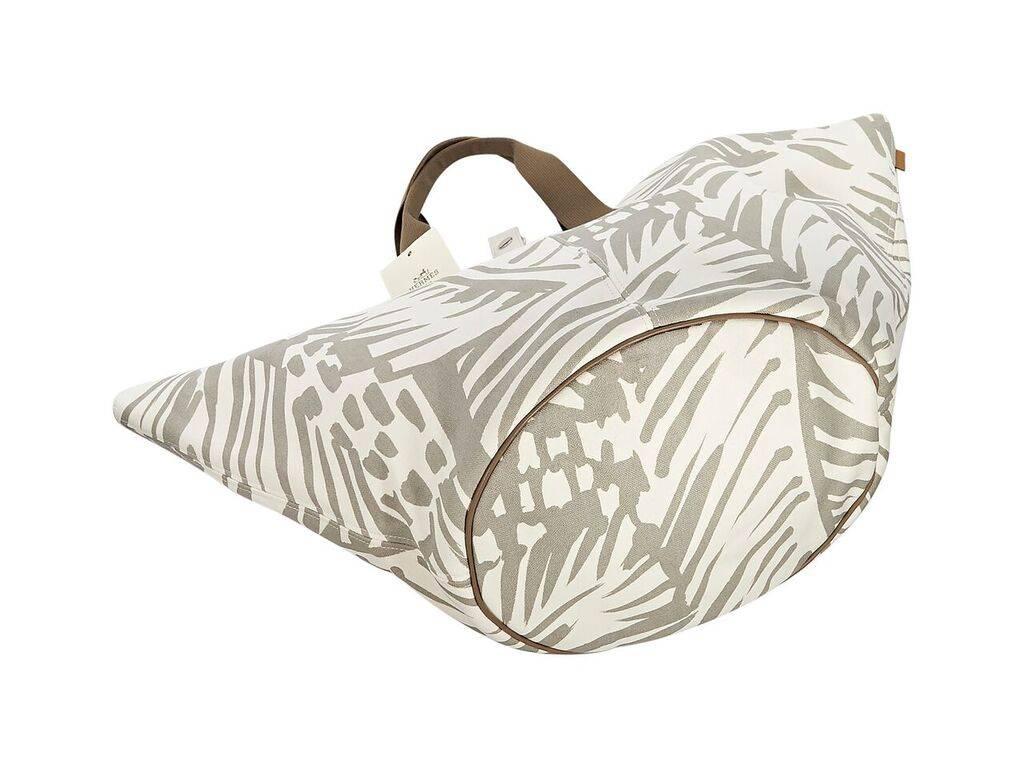 Product details:  Tan and white Sac de Plage Cabas tote bag by Hermes.  Palm-printed design.  Top carry handles.  Top strap closure.  Lined interior.  Dust bag included.  27