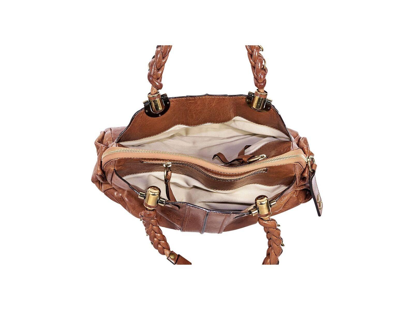 Product details:  Brown leather shoulder bag by Chloe.  Dual braided shoulder straps.  Two open compartments and center top zip close compartment.  Lined interior with inner zip and slide pockets.  Protective metal feet.  Goldtone hardware. 