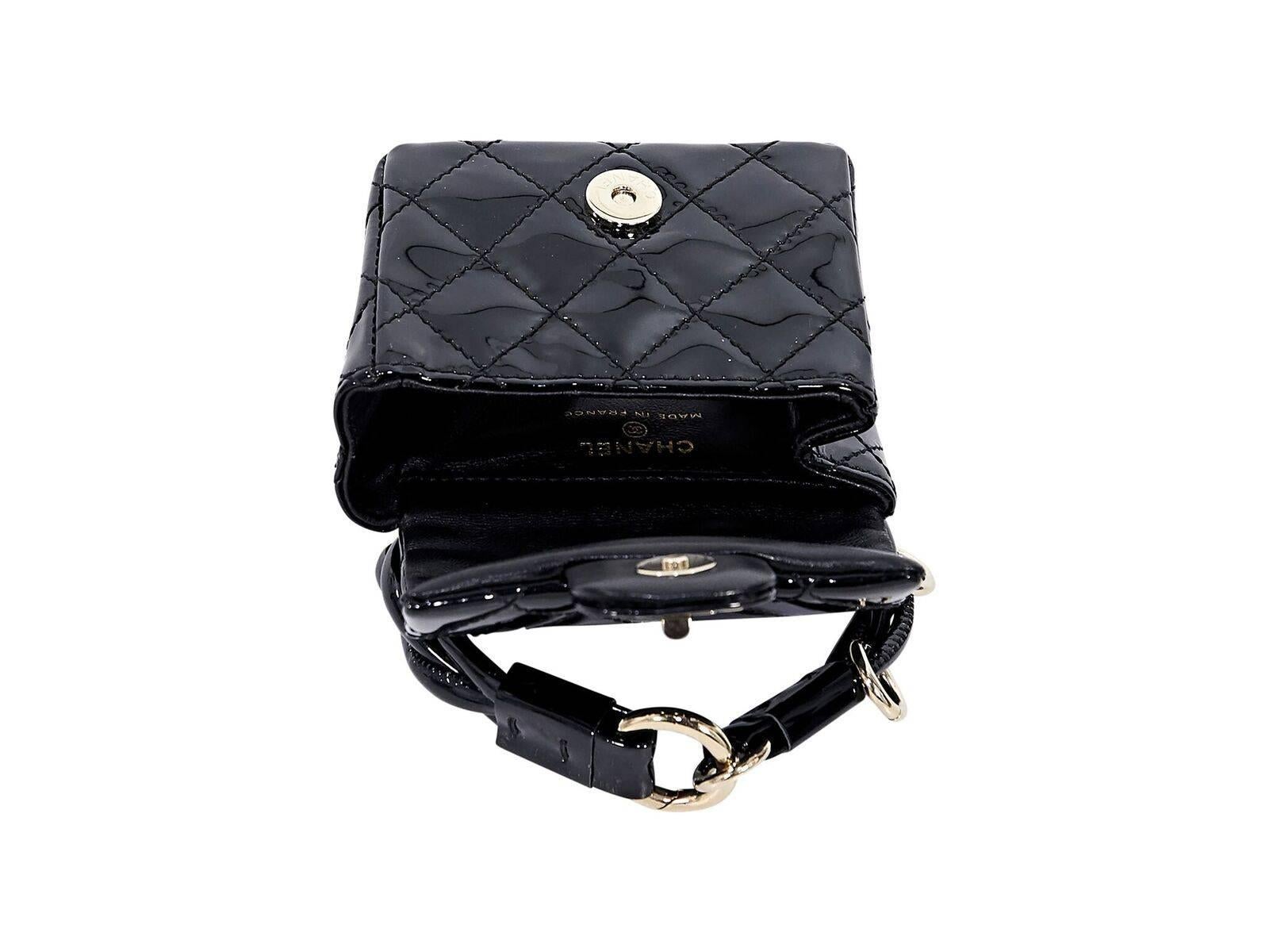 Product details:  Black quilted patent leather ankle bag by Chanel.  Ankle strap with clasp closure.  Front flap with magnetic snap closure.  Faux twist-lock closure.  Lined interior.  Goldtone hardware.  4