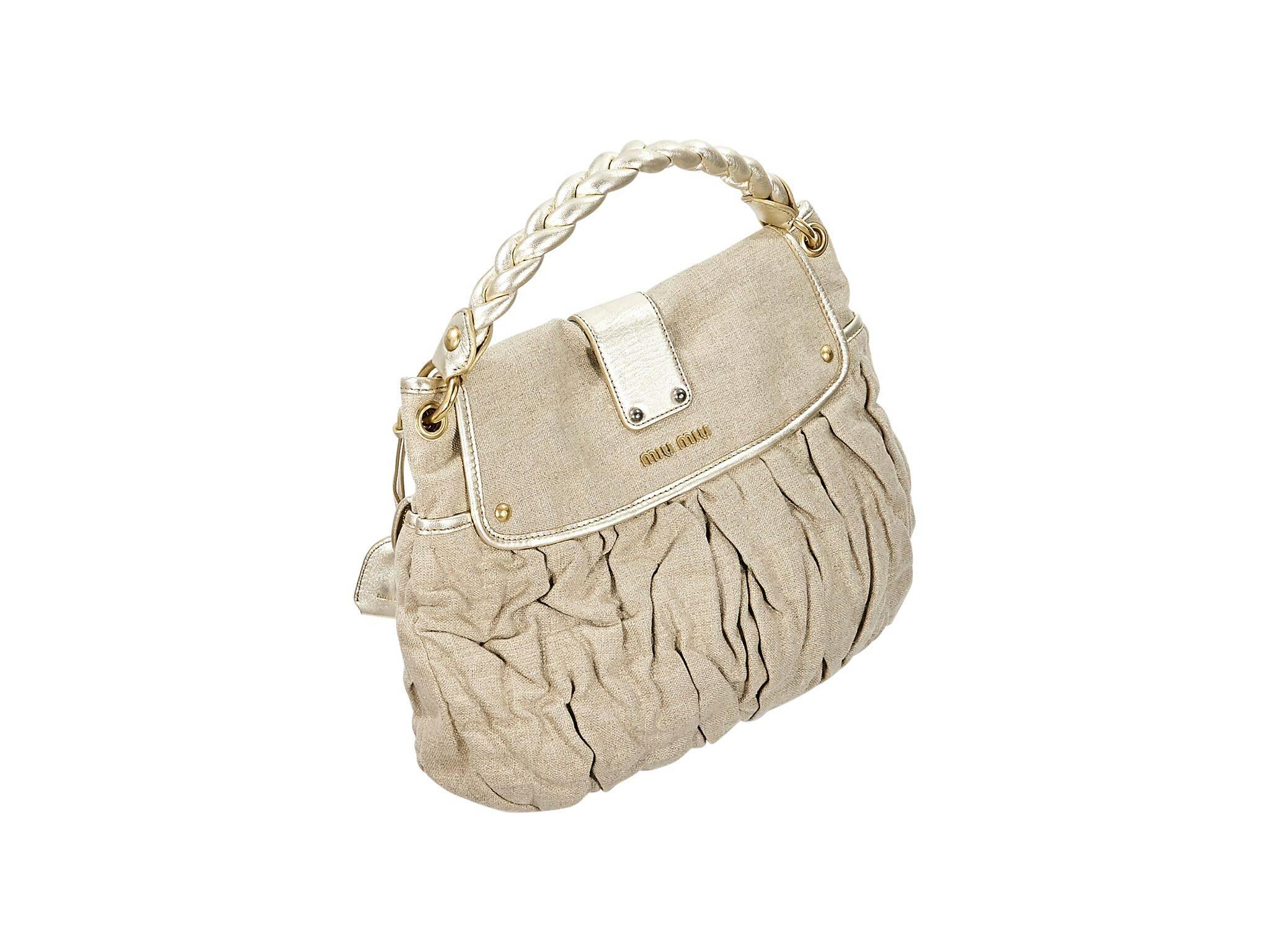 Product details:  Metallic gold canvas shoulder bag by Miu Miu.  Single braided shoulder strap.  Front flap with push-lock clasp closure.  Lined interior with inner zip pocket.  Goldtone hardware.  15.5