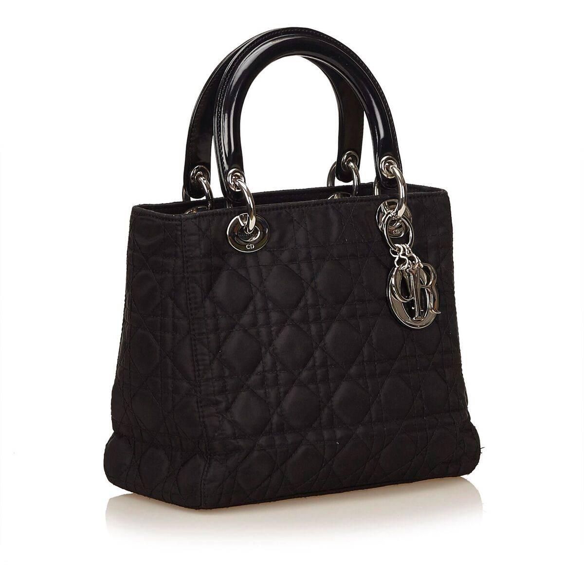 Product details:  Black quilted nylon Lady satchel by Christian Dior.  Dual carry handles.  Detachable shoulder strap.  Top zip closure.  Lined interior with inner zip pocket.  Silvertone hardware.  Authenticity card included.  9