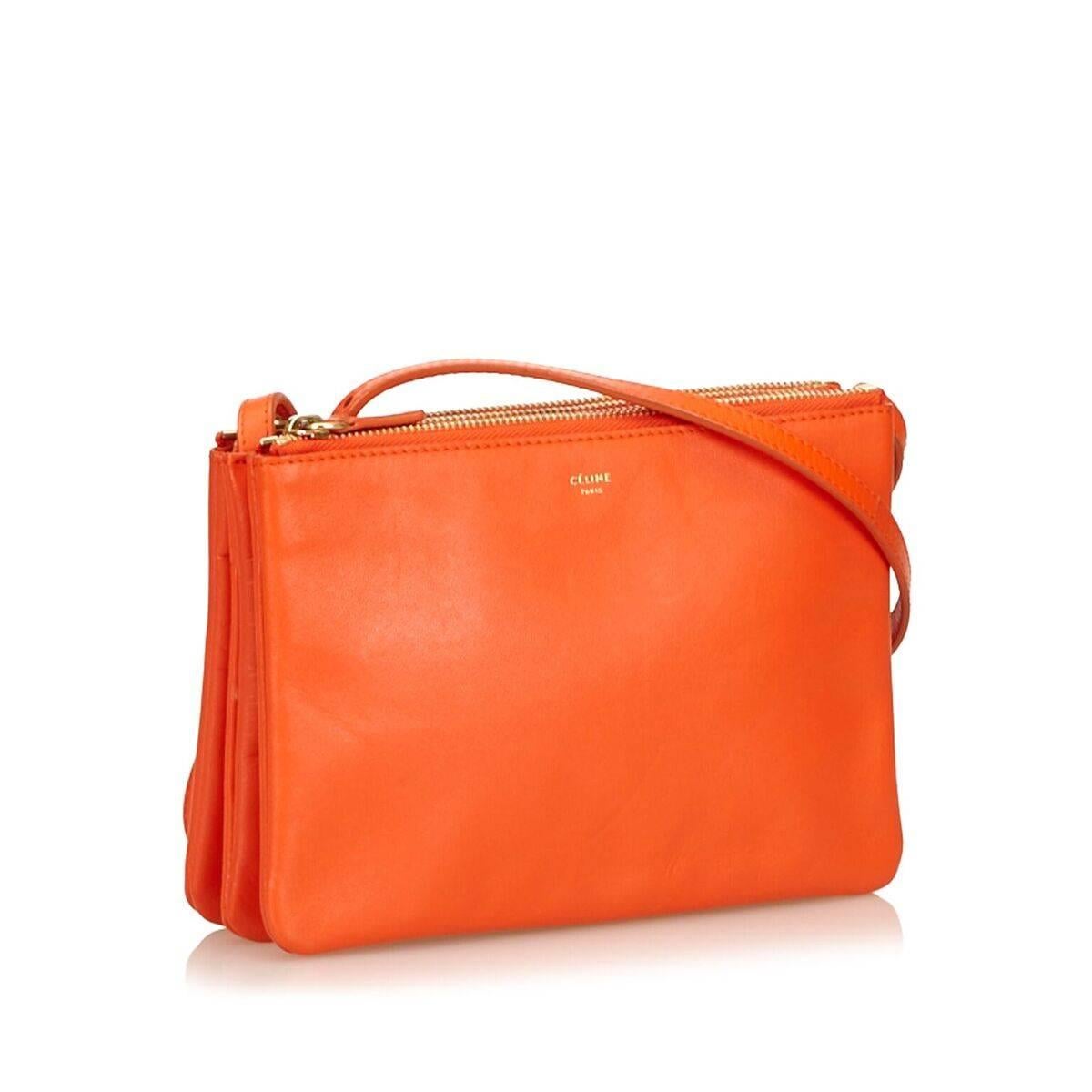 Product details:  Orange leather Trio crossbody bag by Celine.  Crossbody strap.  Triple top zip compartments.  Lined interior.  Goldtone hardware.  Dust bag included.  8