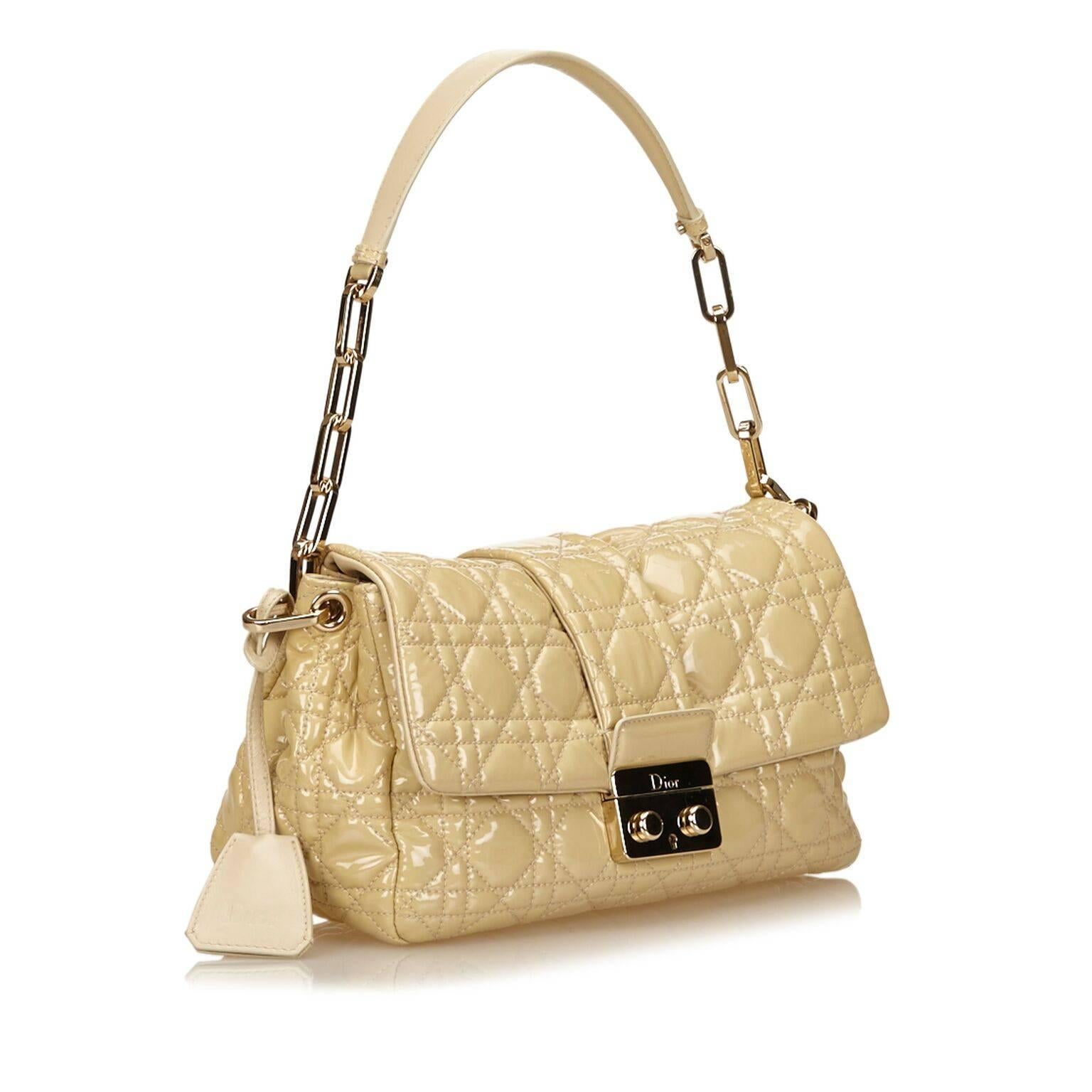 Product details:  Nude quilted patent leather Cannage shoulder bag by Christian Dior.  Single shoulder strap.  Front flap with lock-and-key push-lock closure.  Lined interior with inner zip pocket.  Goldtone hardware.  Authenticity card and dust bag