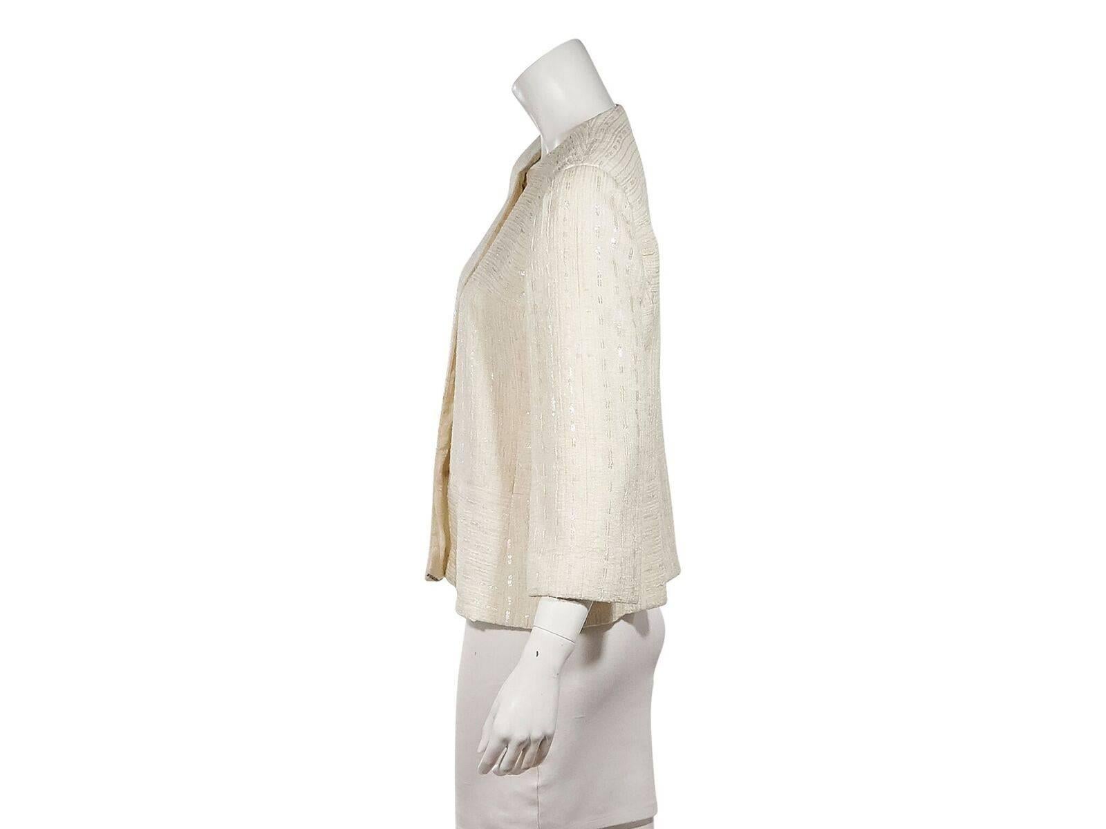 Product details:  Vintage cream jacket by Chanel.  Crewneck.  Three-quarter length sleeves.  Button-front closure.  40