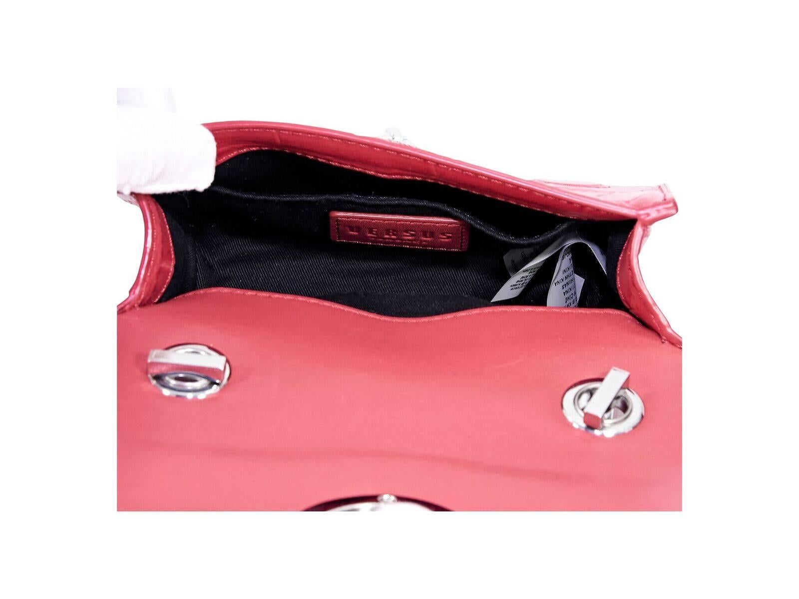 Détails du produit :  Sac à bandoulière en cuir rouge embossé de Versus Versace.  Sangle transversale en chaîne.  Rabat avant accentué d'une tête de lion.  Intérieur doublé avec pochette intérieure coulissante.  Matériel argenté.  6.5 