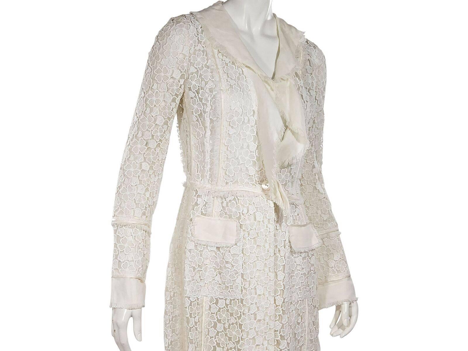 Product details:  White ruffle-trimmed lace coat by Dolce & Gabbana.  Long sleeves.  Single-button closure.  Waist patch pockets.  36