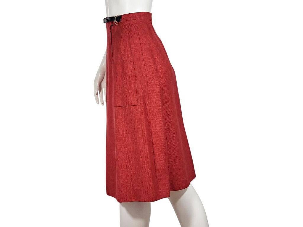 Product details:  Vintage red A-line skirt by Hermes.  Banded waist with belt front.  Double zip closure.  Front patch pockets.  Goldtone hardware.  Label size FR 38.  26