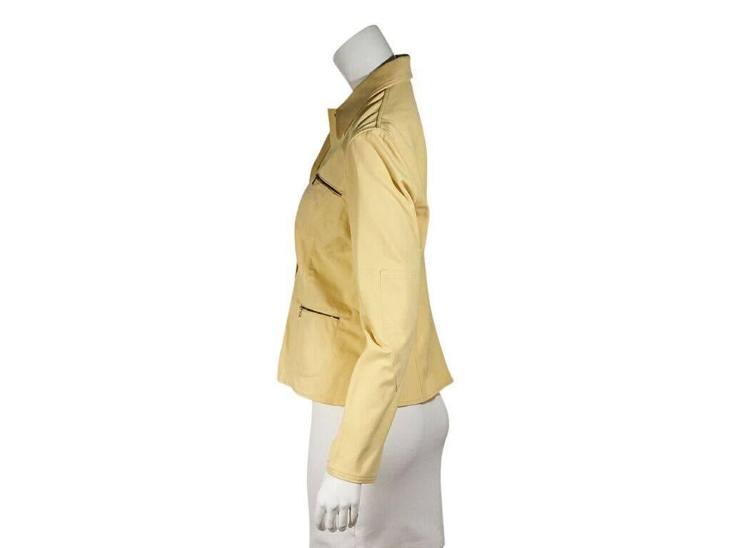Product details:  Vintage yellow cotton pant suit by Gucci.  Spread collar.  Long sleeves.  Button-front closure.  Four front zip pockets.  Matching pants.  Banded waist with belt loops.  Button and zip fly closure.  Zip waist pocket.  Label size IT