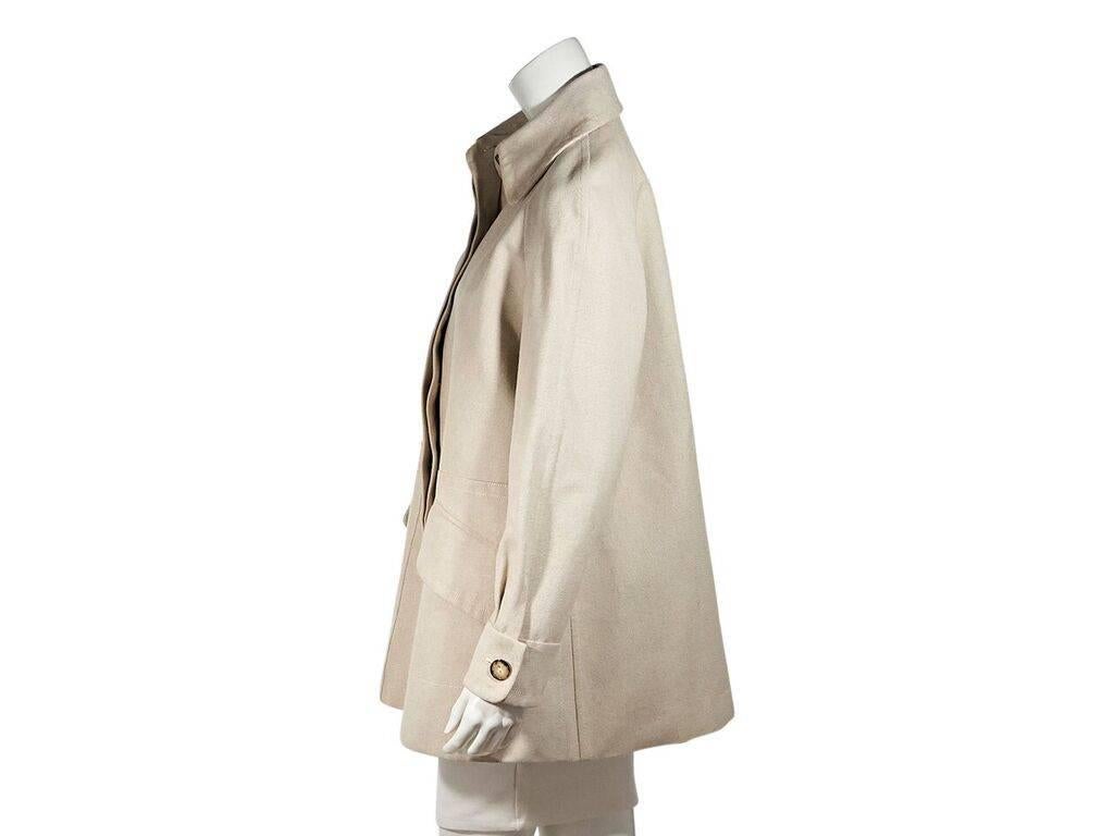 Product details:  Vintage tan cotton coat by Hermes.  Spread collar.  Long sleeves.  Single button cuffs.  Concealed button-front closure.  Waist flap pockets.  Back concealed zip-close box pleat.  Label size FR 42.  42