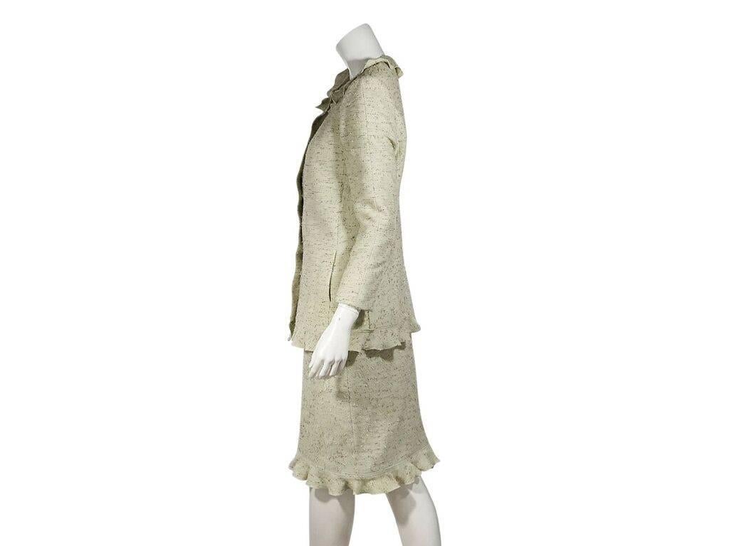 Product details:  Light green tweed skirt suit set by Chanel.  Ruffle-trimmed jewelneck.  Three-quarter length sleeves.  Button-front closure.  Matching skirt.  Banded waist.  Ruffle hem.  Jacket:  36