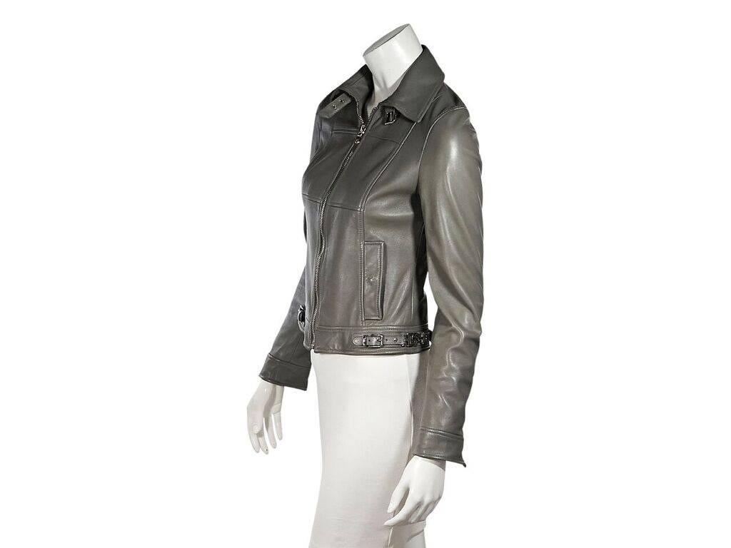 Product details:  Grey leather jacket by Dolce & Gabbana.  Spread collar with adjustable buckle closure.  Long sleeves.  Zip cuffs.  Zip-front closure.  Waist snap pockets.  Side hem buckle details.  Silvertone hardware.  EU size 38.  32