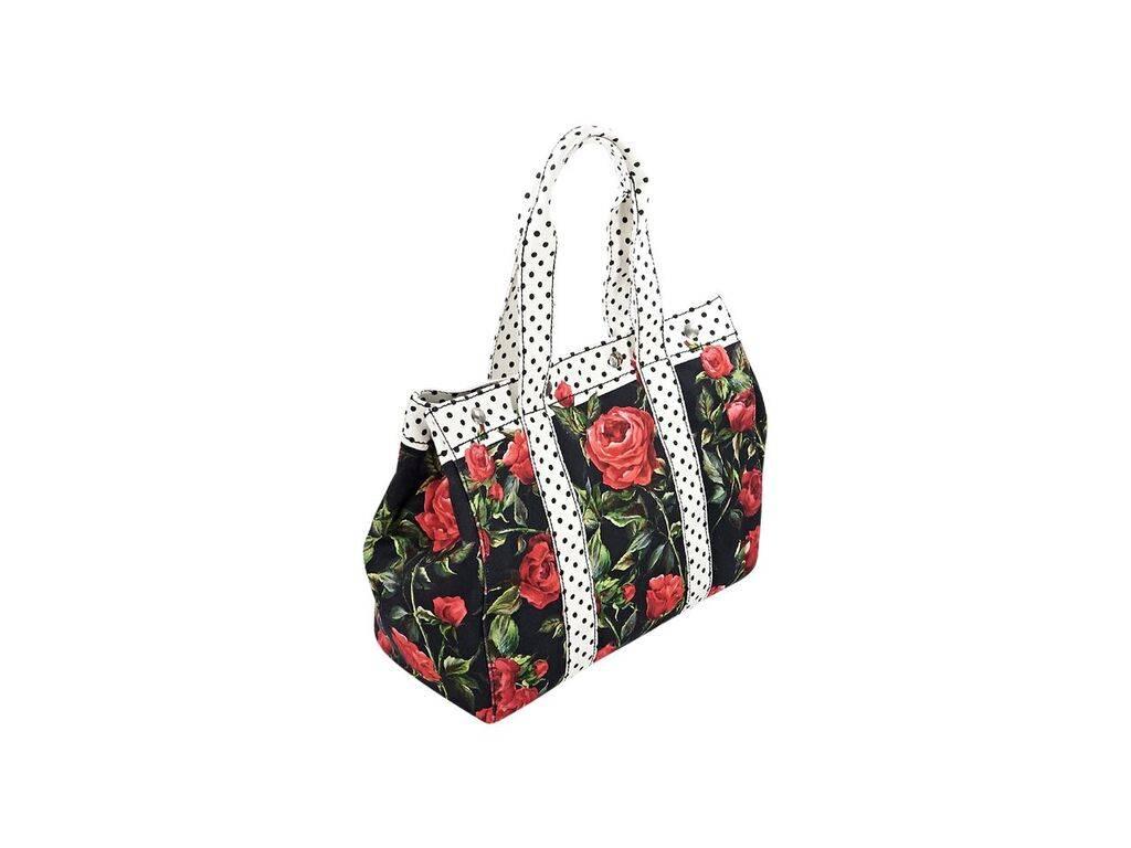 Product details:  Multicolor floral-printed canvas tote bag by Dolce & Gabbana.  Trimmed with polka-dot design.  Dual shoulder straps.  Top snap closure.  Lined interior with inner zip and slide pockets.  Flat bottom with protective metal feet. 