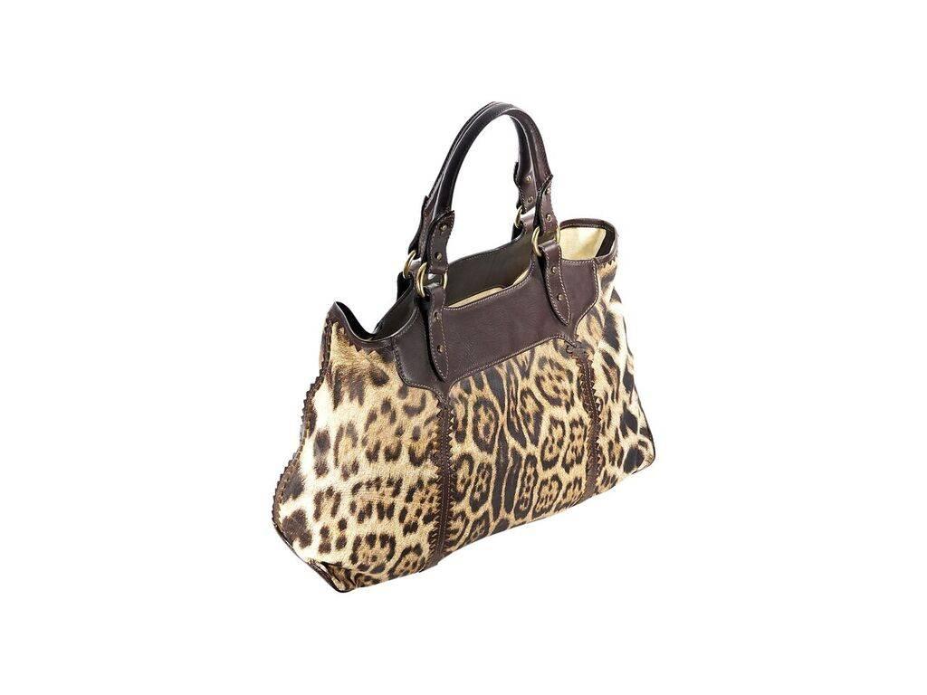 Product details:  Multicolor leopard-print tote bag by Roberto Cavalli.  Trimmed with brown leather.  Dual carry handles.  Top zip closure.  Lined interior.  Antiqued goldtone hardware.  23