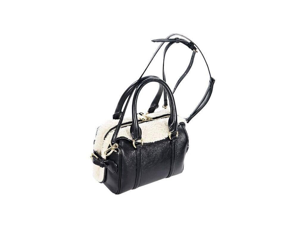 Product details:  Black leather mini Bee bowler satchel by Burberry Prorsum.  Trimmed with white shearling fur.  Dual carry handles.  Detachable, adjustable crossbody strap.  Top zip closure.  Lined interior with inner zip and slide pockets. 