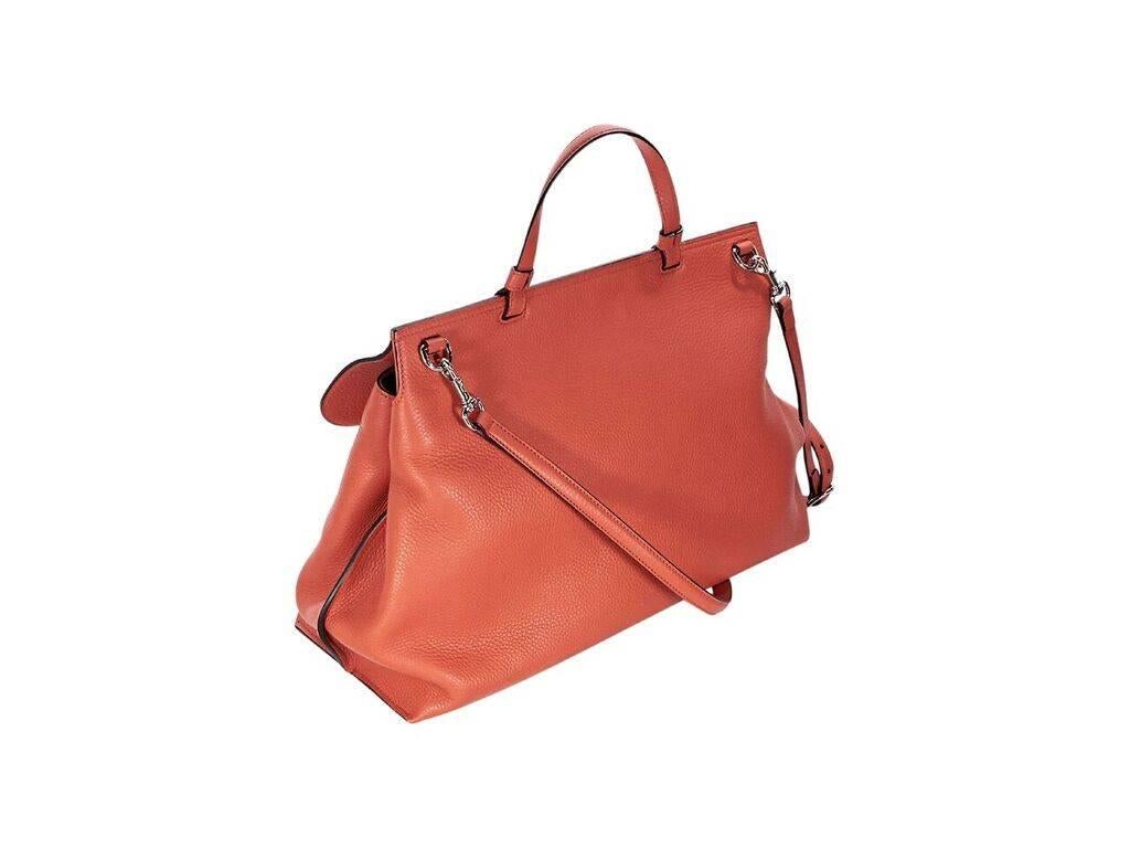 Product details:  Orange pebbled leather Daily satchel by Gucci.  Top carry handle.  Detachable, adjustable crossbody strap.  Front flap with bamboo twist-lock closure.  Lined interior with inner zip pocket.  Magnetic sides.  Silvertone hardware. 