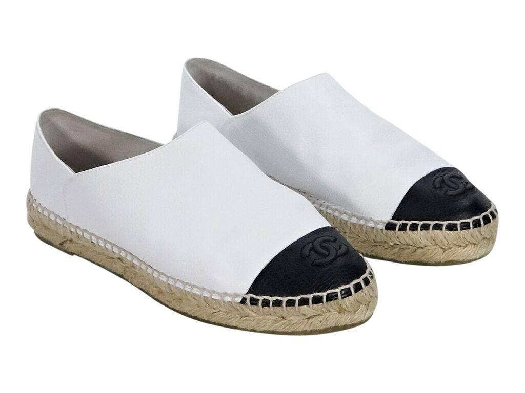 Product details:  White and black leather flat espadrilles by Chanel.  Round cap toe accented with embossed logo detail.  Label size FR 39.
Condition: Pre-owned. Very good.
