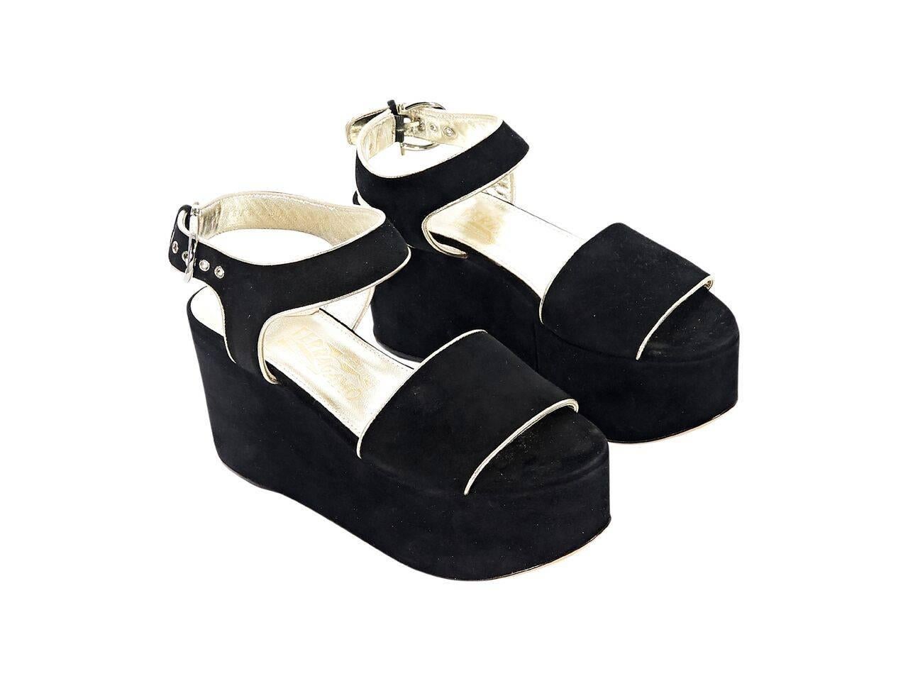 Product details:  Black suede wedge sandals by Salvatore Ferragamo.  Trimmed with goldtone piping.  Adjustable ankle strap.  Open toe.  Goldtone hardware.  3.5