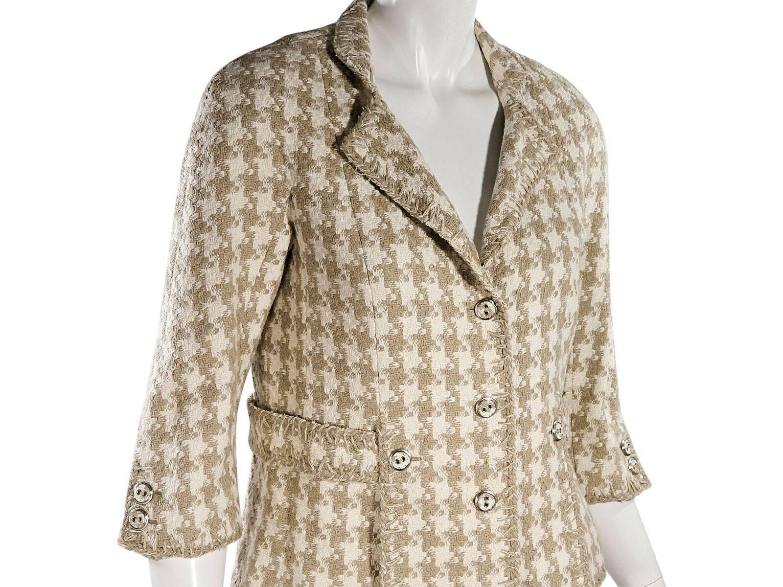 Product details:  Tan and white silk boucle jacket by Chanel.  Notched lapel.  Elbow-length sleeves.  Double-button detail at cuffs.  Button-front closure.  Silvertone hardware.  Label size FR 42.  34