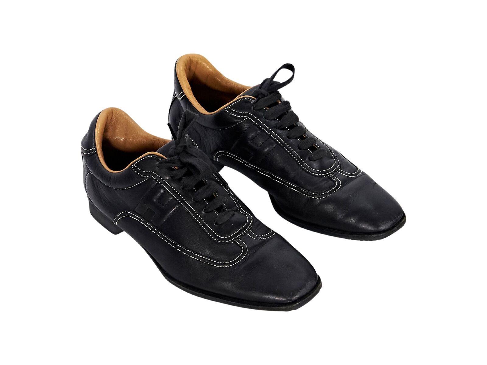 Product details:  Black leather sneakers by Hermes.  Accented with white topstitching.  Lace-up closure.  Square toe.  
Condition: Pre-owned. Very good.
Est. Retail $ 1,035.00
