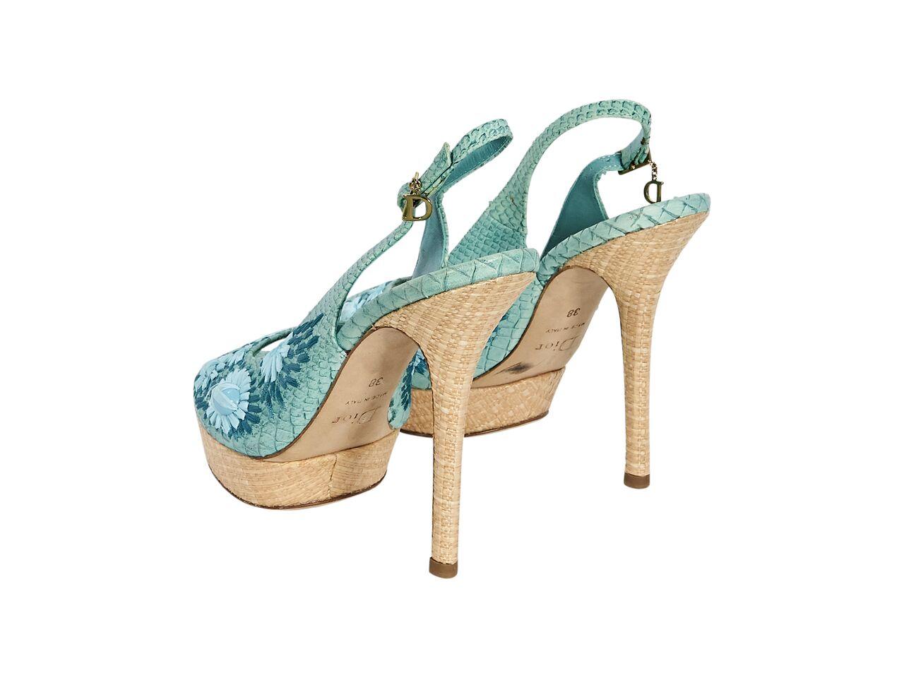 Product details:  Teal snake-embossed leather slingback pumps by Christian Dior.  Accented with floral applique.  Adjustable slingback strap.  Peep toe.  Towering tan woven heel and platform design.  5