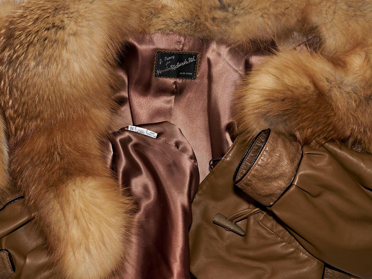 Product details:  Vintage brown leather coat by J. Percy for Marvin Richards Ltd.  Accented with fox fur.  Shawl collar.  Long sleeves.  Front waist pockets.  Inset drawstring with toggle closure.  44