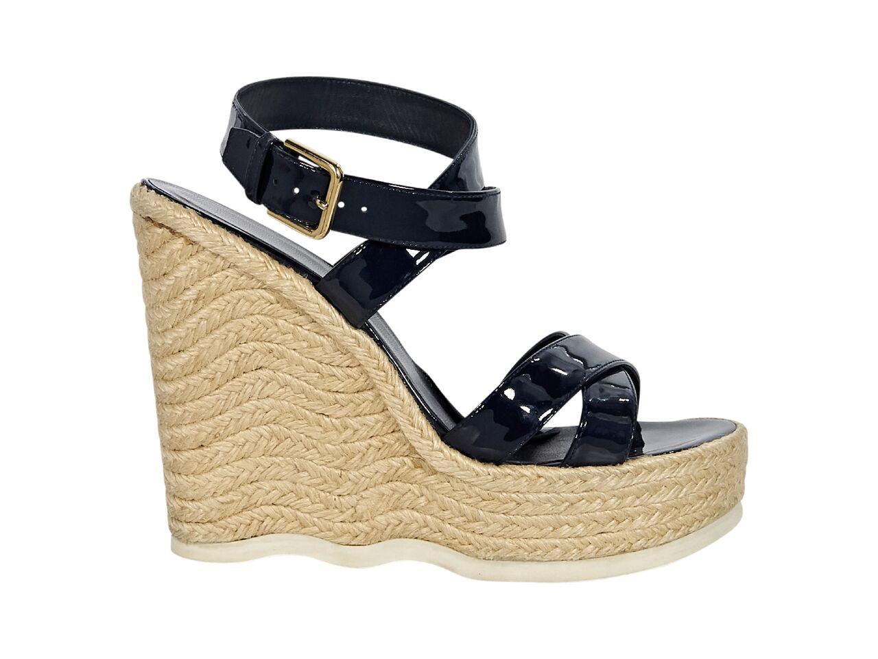 Product details:  Navy blue patent leather strappy wedge espadrille sandals by Yves Saint Laurent.  Adjustable ankle strap.  Open toe.  Goldtone hardware.  5