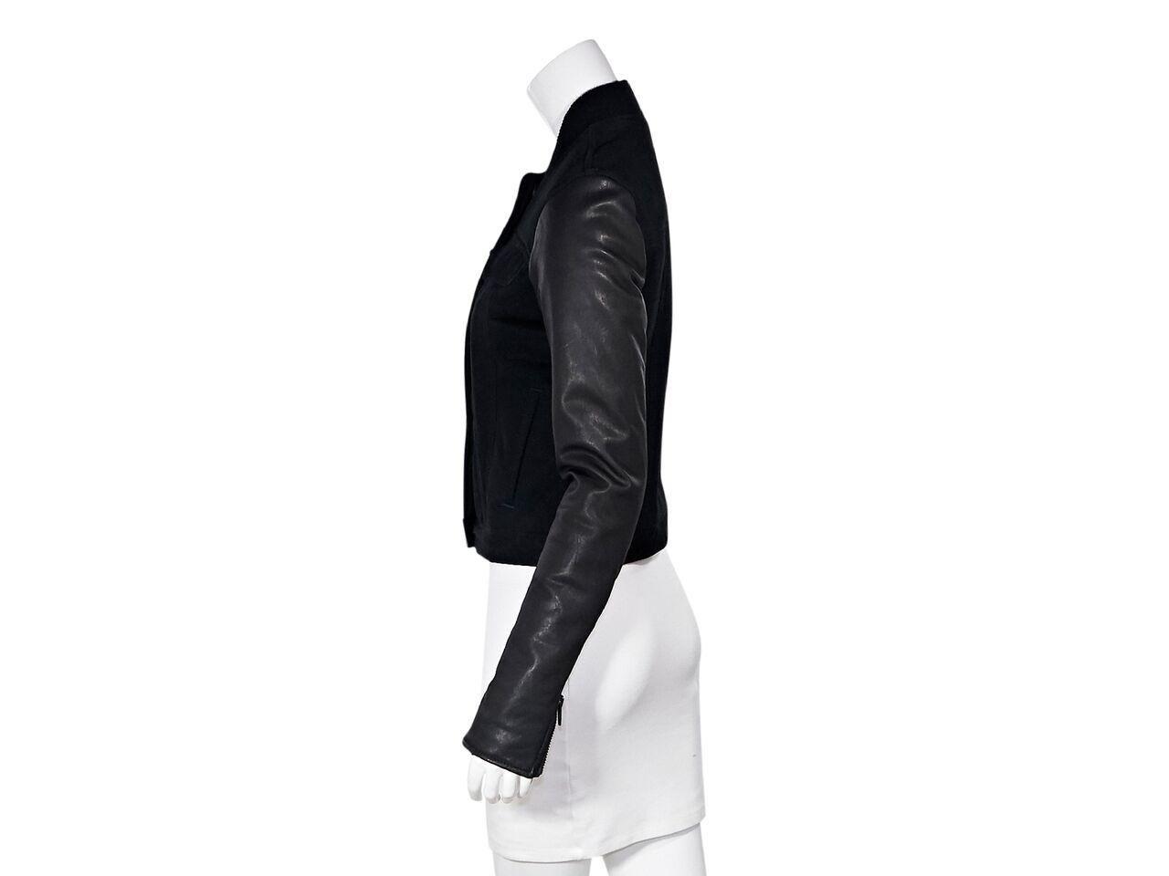 Product details:  Black stretch cotton denim jacket by Alexander Wang.  Ribbed stand collar.  Long leather sleeves.  Zip cuffs.  Concealed button-front closure.  Chest flap pockets.  Waist slide pockets.  32