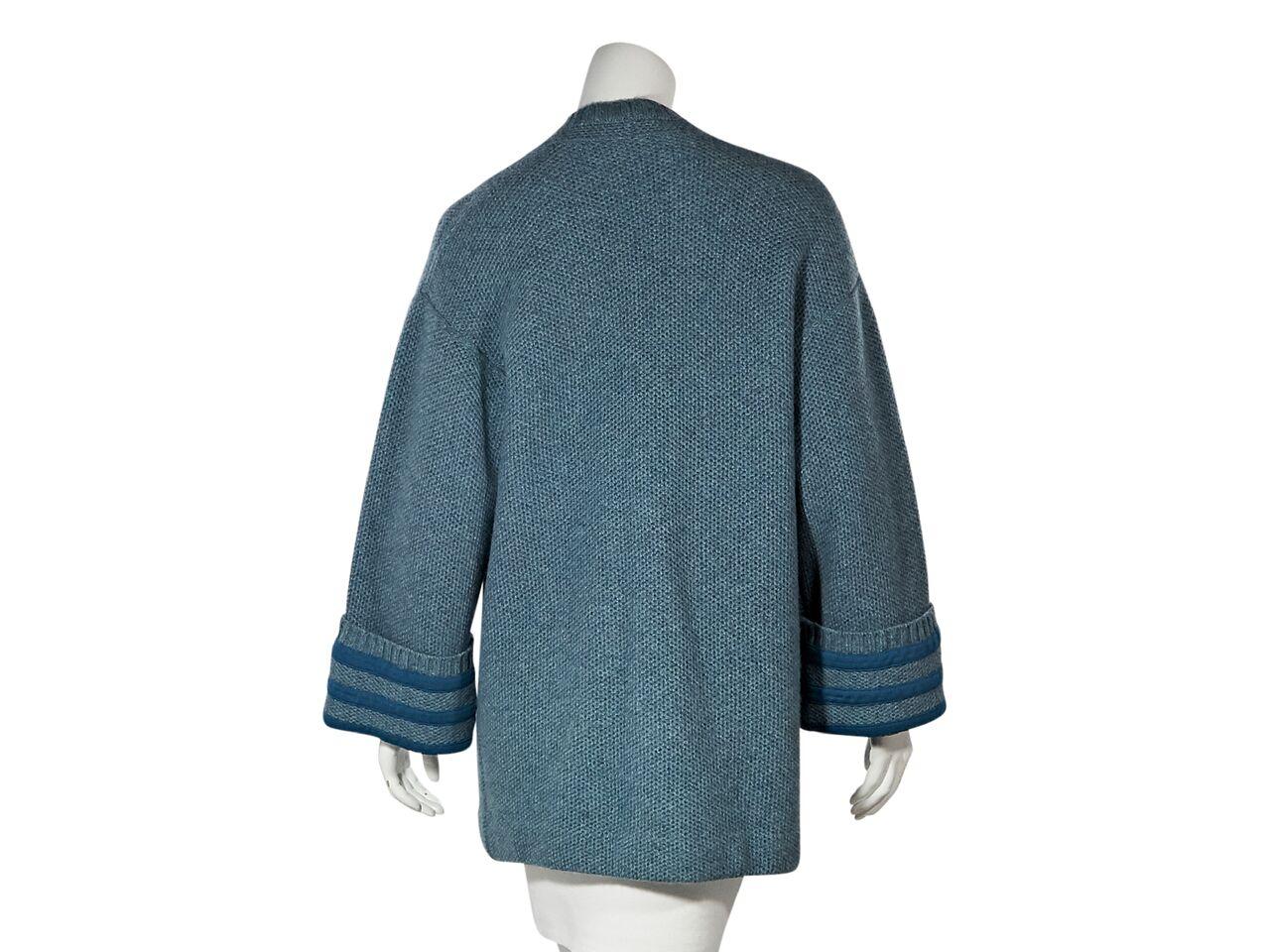 Product details:  Blue cashmere cardigan by Chanel.  Deep v-neck.  Long sleeves.  Striped cuffs.  Button-front closure.   Patch front pockets.  42