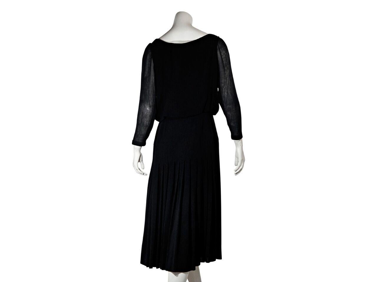 Product details:  Vintage black faux wrap dress by Chanel.  Deep v-neck.  Bracelet-length sleeves.  Button-front closure.  Pleated skirting.  Goldtone hardware. 35.5