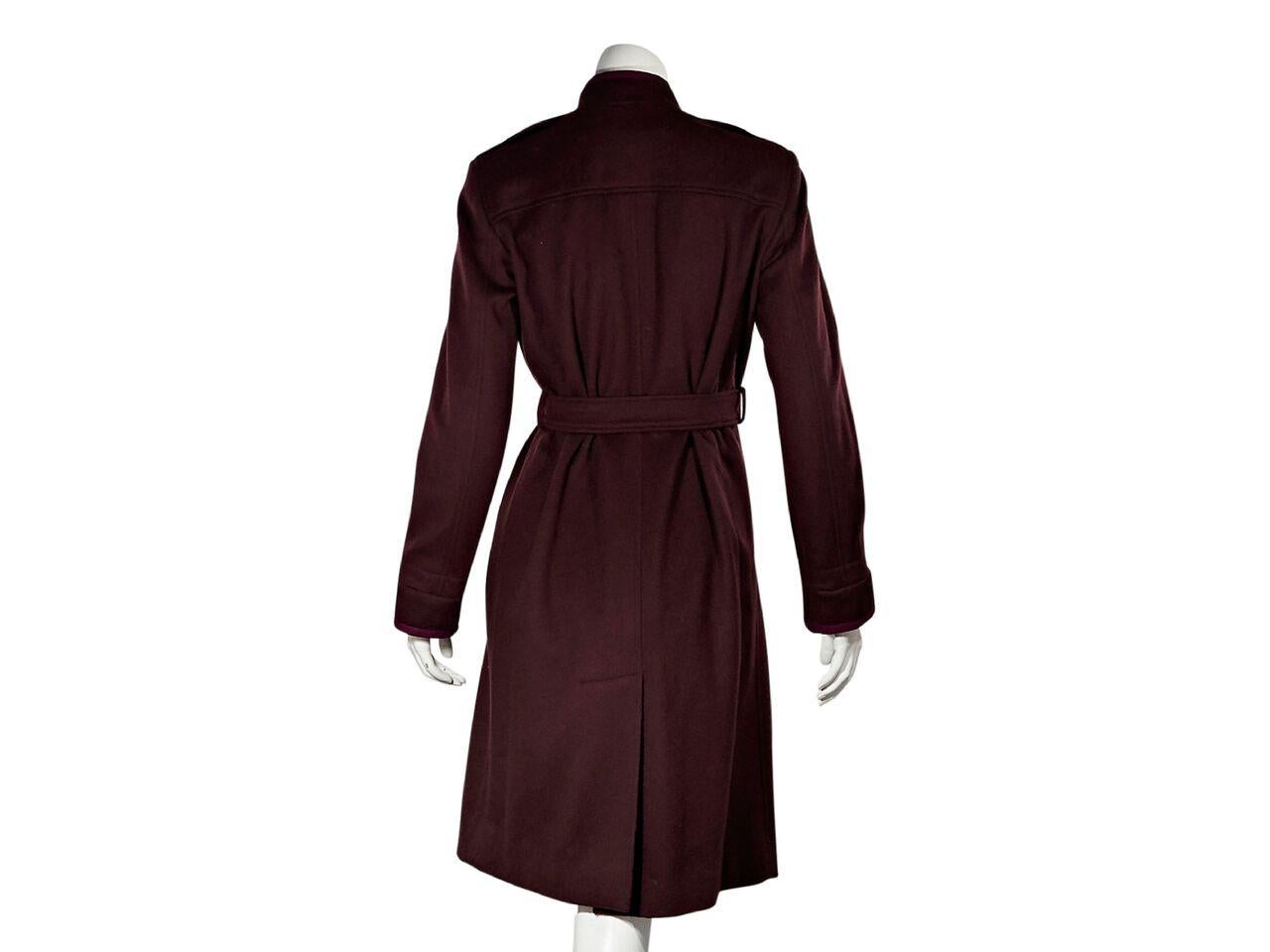 Product details:  Vintage burgundy long wool coat by Yves Saint Laurent.  Stand collar.  Long sleeves.  Button-front closure.  Adjustable belted waist.  Front slide pockets.  Back hem vent.  38