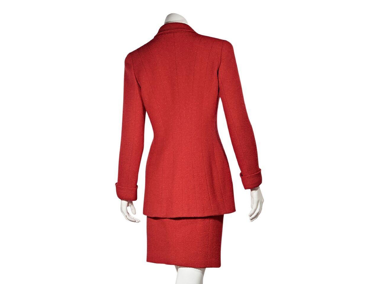 Product details:  Vintage red wool-blend skirt suit set by Chanel.  Notched lapel.  Long sleeves.  Double-breasted button front.  Button patch front pockets.  Back seams create a flattering silhouette.  Matching skirt.  Banded waist.  Concealed side