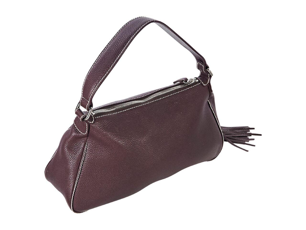 Product details:  Vintage burgundy pebbled leather shoulder bag by Chanel.  Features white topstitching.  Single shoulder strap.  Lined interior with inner zip pocket.  Exterior zip front pocket with tassel pull.  Silvertone hardware.  15