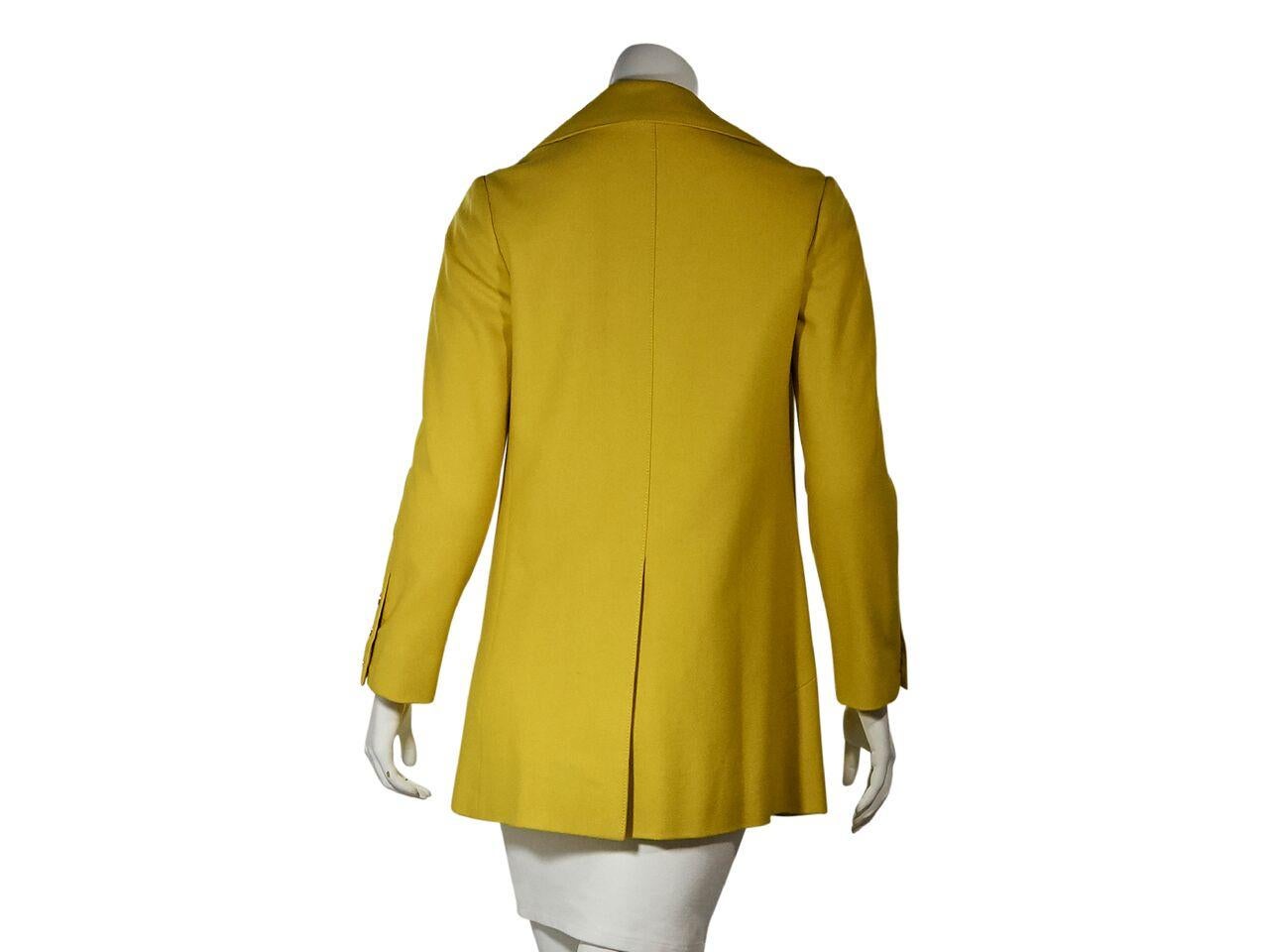 Product details:  Vintage yellow wool jacket by Hermes.  Oversized notched lapel.  Long sleeves.  Three-button detail at cuffs.  Button-front closure.  Front slide pockets.  Center back hem vent.  Goldtone hardware.  35.5