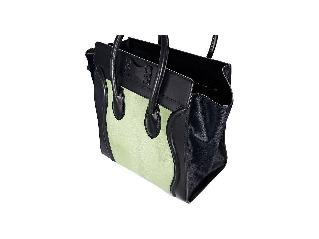 Product details:  Black and mint green pony hair luggage tote bag by Celine.  Trimmed with leather.  Top carry handles.  Top zip closure.  Leather interior with inner zip and slide pockets.  Front exterior zip pocket.  Protective metal feet. 