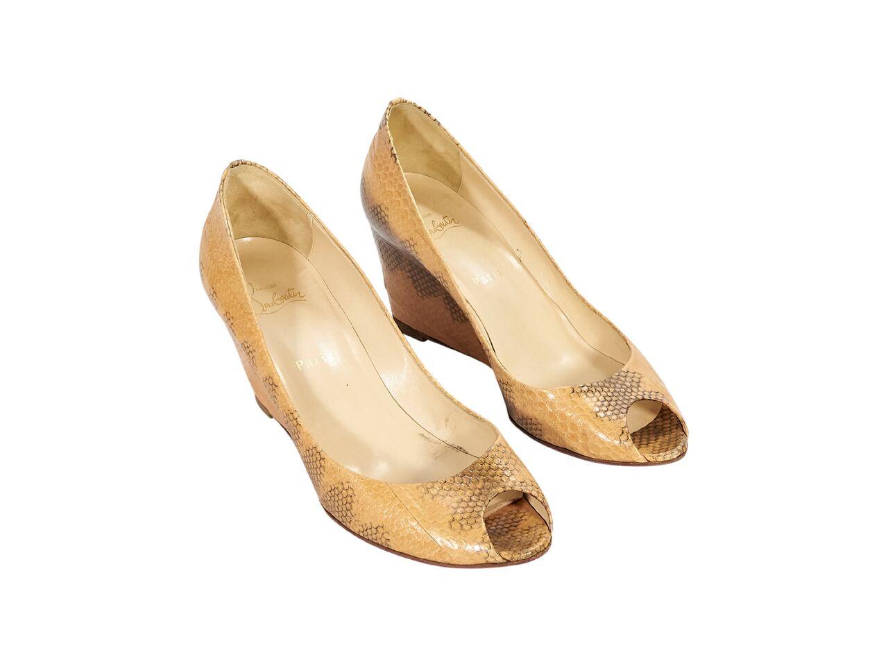 Product details:  Tan snakeskin wedges by Christian Louboutin.  Peep toe.  Iconic red sole.  Slip-on style.  3.5