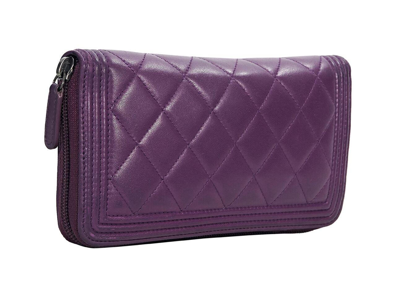 Product details:  Purple quilted leather Boy wallet by Chanel.  Zip-around closure.  Leather lined interior with multiple inner credit card slots and center zip coin pouch.  Antiqued silvertone hardware.  Dust bag included.  8